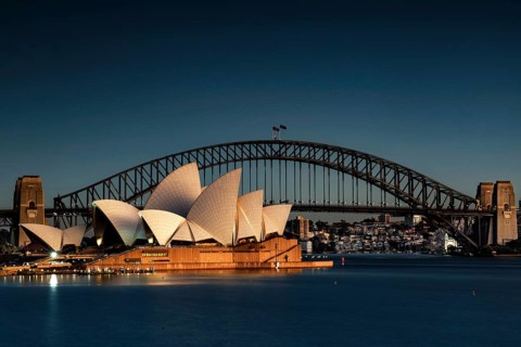 Illuminated opera house and harbour bridge in front of the night skyline of Sydney, Sydney, New