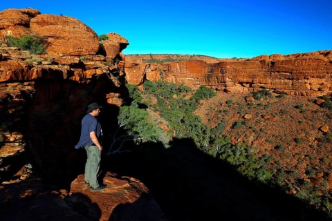 Person standing at the edge of Kings Canyon with deep views of the valley, Watarrka National Park,