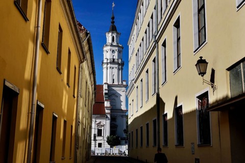 Kaunas Town Hall viewed through a shady alley on sunny Town Hall Square, Rathausplatz,