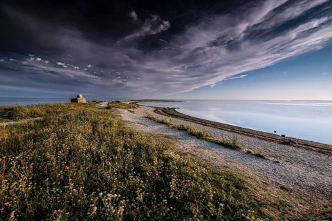 Tranquil stretch of coast with dramatic skies and soft grass, Särve, Saaremaa, Estonia