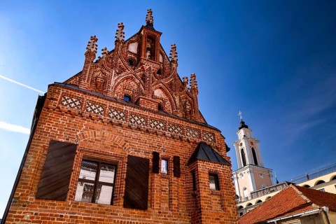 Gothic brick building with distinctive tiled roof and tower in the blue sky, Kaunas, Lithuania