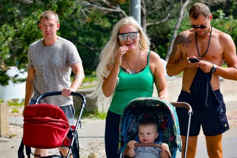 A family with stroller strolls along the promenade, Pärnu, Estonia on a sunny day