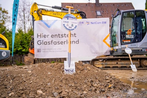 Construction site for fibre-optic expansion with excavators and signs in the background, fiberglass