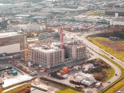 Aerial view of a construction site of a new hospital in an industrial area with buildings and