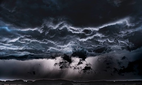 Threatening storm clouds criss-cross the dark sky, Osnabrücker Land, Wiehen Mountains, Lower