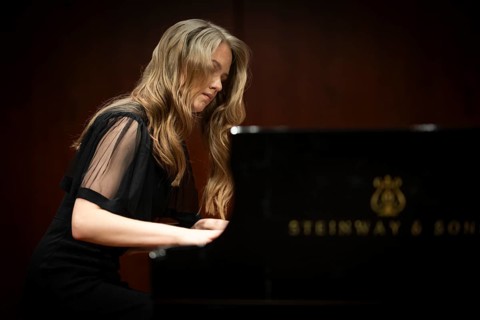 Young woman, pianist, pianist with concentrated facial expression playing on a Steinway & Sons