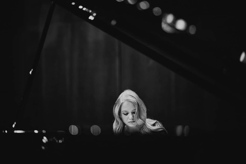 Young woman, pianist, with concentrated facial expression playing on a Steinway & Sons grand piano,