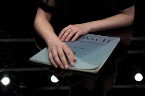 Hands of a young pianist rest on notes from Johann Sebastian Bach, Steinway & Sons-Flügel,