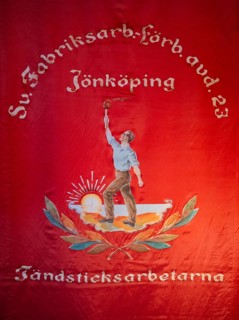 Red flag showing a worker with a torch in front of the rising sun, Tändsticksmuseet match museum or