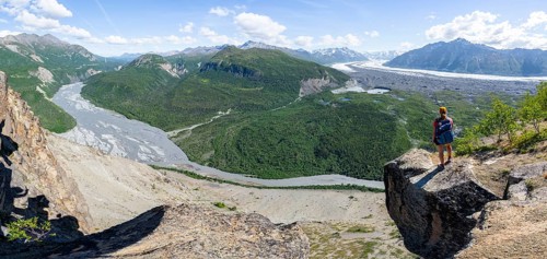 Panorama, young woman on a rocky outcrop enjoying the view, view of impressive mountain landscape