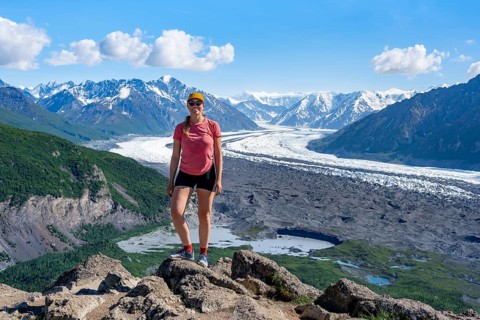 Young woman in front of impressive mountain landscape with Matanuska glacier and glaciated mountain
