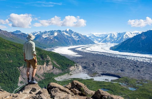 Young man enjoying the view, view of impressive mountain landscape with Matanuska glacier and