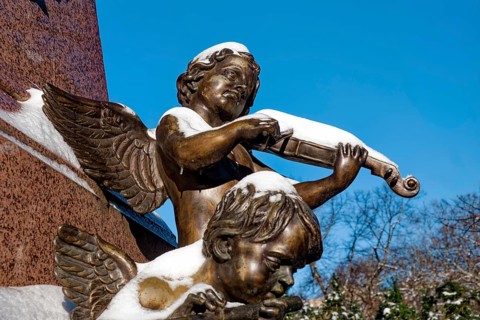 An angel playing the violin, figure at the Felix Mendessohn Bartholdy monument in winter with snow,