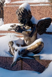 An angel playing the flute, figure at the Felix Mendessohn Bartholdy monument in winter with snow,