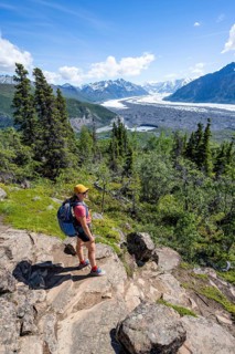 Young woman enjoying the view, view of impressive mountain landscape with Matanuska glacier and