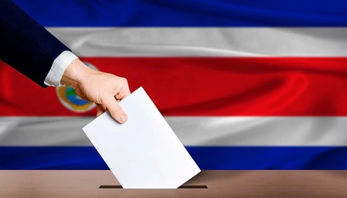 Costa Rica presidential vote 2026. Hand placing a ballot in ballot box with the Costa Rican flag in
