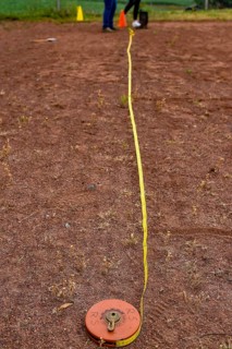 A tape measure and a sports disc lie on an ash track, marking a point in competition, Lower Saxony,