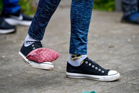 A person with patterned socks and padded shoes stands on a paved floor, Sports and Fun Olympiad