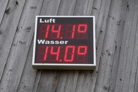Digital thermometer for air and water hangs on a wooden wall, shows 14.1 degrees for air and 14