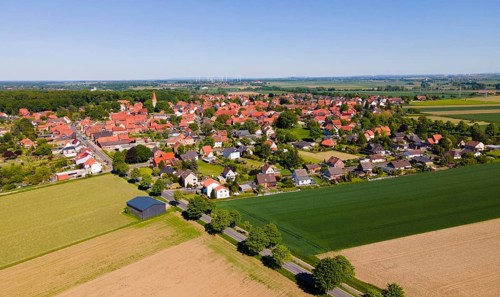 Panoramic summer view of a village with red roofs and wide fields, Adenstedt, Ilsede municipality,