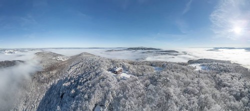 Aerial view of snowy stone walls with shelter and fog in the valley, Schwarzensee, Weissenbach an