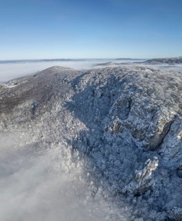 Aerial view of snowy stone walls and fog in the valley, Schwarzensee, Weissenbach an der Triesting,