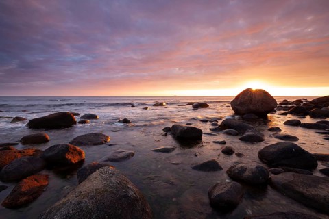 Rocky bay under a dramatic glowing sky at the coast. unset, Vigrestad, Rogaland, Norway