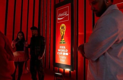 Football fans poses for a photograph with the original FIFA World Cup 2026 Trophy during the