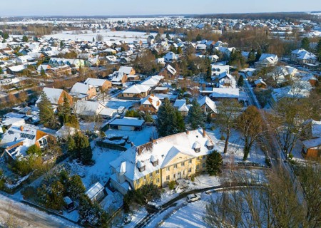 Residential area in winter with snow-covered classic buildings and trees, aerial view,