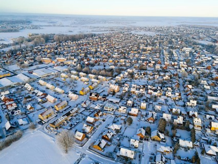 Snowy village landscape in evening light with numerous houses and roads, aerial view, Oelsburg,
