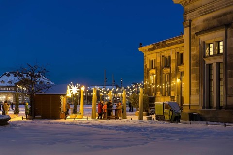 Mulled wine stand behind the Schinkelwache with a view of the Semper Opera House with fairy lights