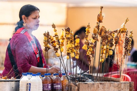 Vendor selling roasted meat at a stall in Bhogali Mela, ahead of the 'Magh Bihu' festival, in