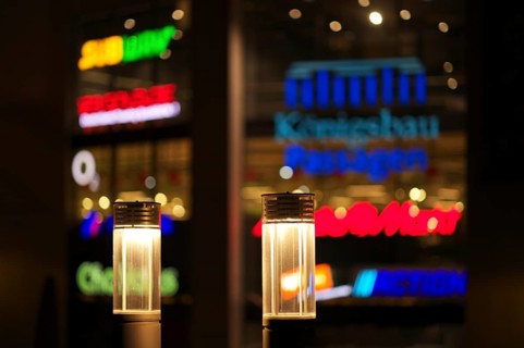Night view, street lamps, neon lighting behind in blur, logo Mediamarkt, Tegut, Action, Subway,