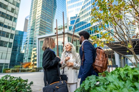 Diverse business professionals conversing and networking outdoors in a vibrant urban environment,