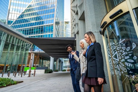 Diverse business colleagues walking and talking together, sharing ideas while navigating a modern