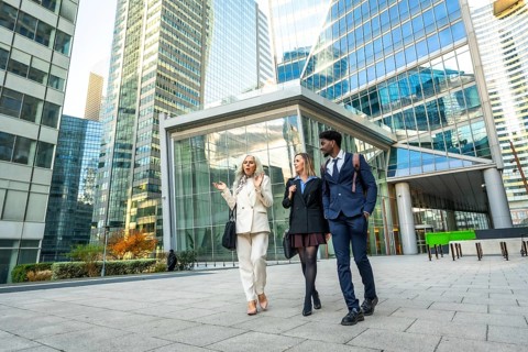 Diverse business professionals walking and discussing outdoors in a contemporary financial