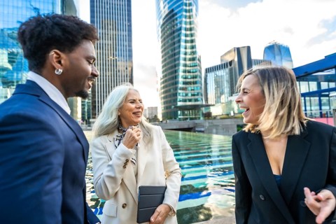 Diverse business professionals having a joyful outdoor conversation and networking session in a