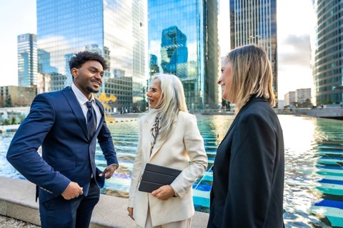 Diverse business professionals having a dynamic informal meeting and discussing ideas outdoors in a