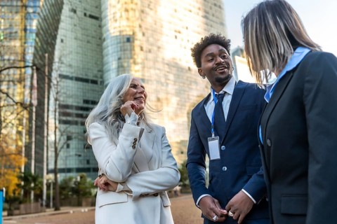 Diverse business professionals sharing a cheerful conversation and networking outdoors in an urban