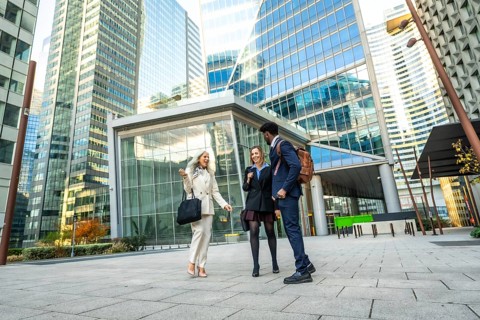 Diverse business professionals having a conversation while walking together through a modern urban