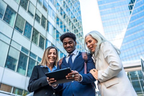 Diverse business professionals reviewing content on a digital tablet, fostering collaboration and