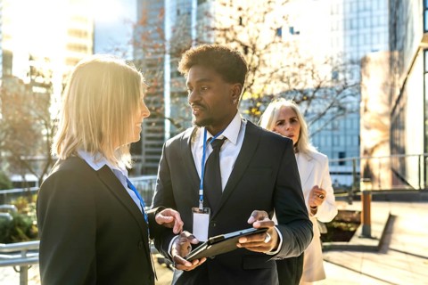 Diverse business professionals networking and collaborating while reviewing information on a