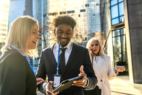Diverse business people working together outdoors in a city, exchanging ideas and smiling while