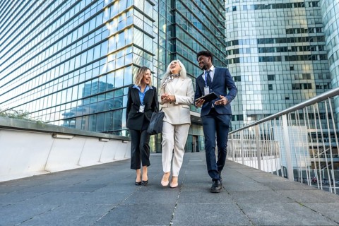 Three diverse business professionals. Including a young black man. A mature woman. And a young