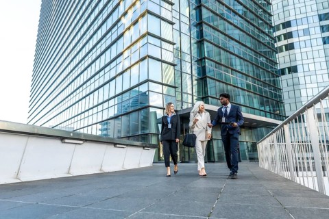 Business professionals of different ages and ethnicities are walking together, smiling, and having