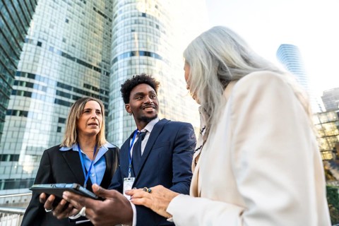 Diverse business professionals discussing projects and ideas during an outdoor meeting in a modern