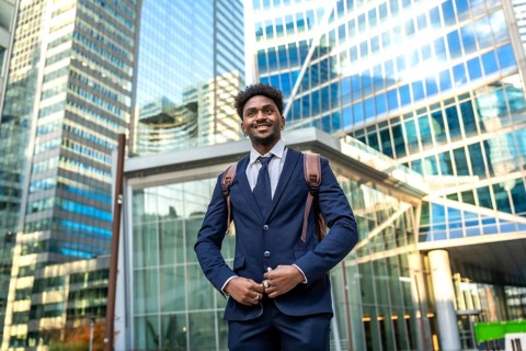 Young african american businessman smiling, looking ahead while standing confidently with a
