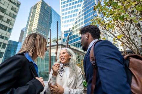 Diverse group of business people collaborating and networking outside in a modern office district,