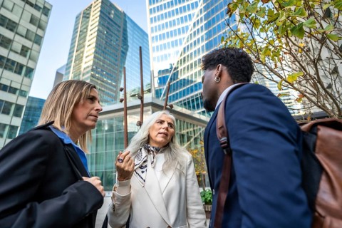 Professionals engaging in a focused conversation outside office buildings, representing