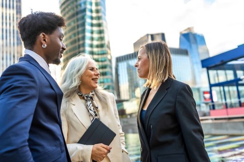 Diverse business people engaging in a professional discussion and teamwork, collaborating outdoors